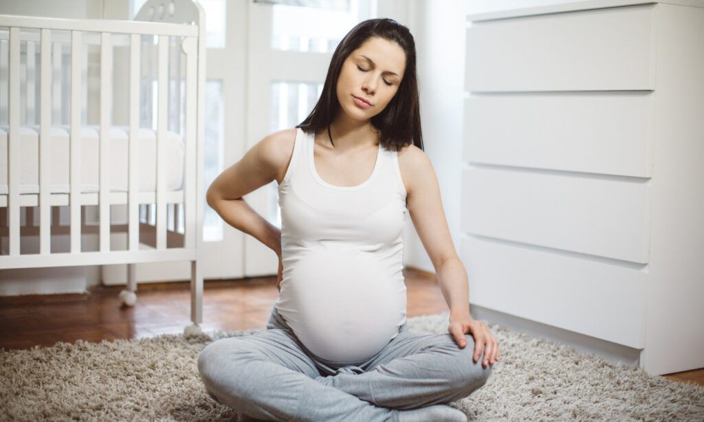 A pregnant woman experiencing back pain, receiving chiropractic care at Spinal Care in Sydney.